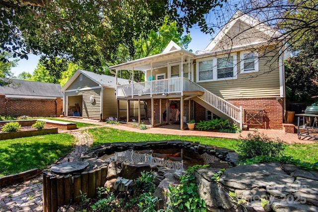 116 N Mulberry St, Statesville, NC 28677 - back of house featuring brick siding, stairs, a lawn, and a patio
