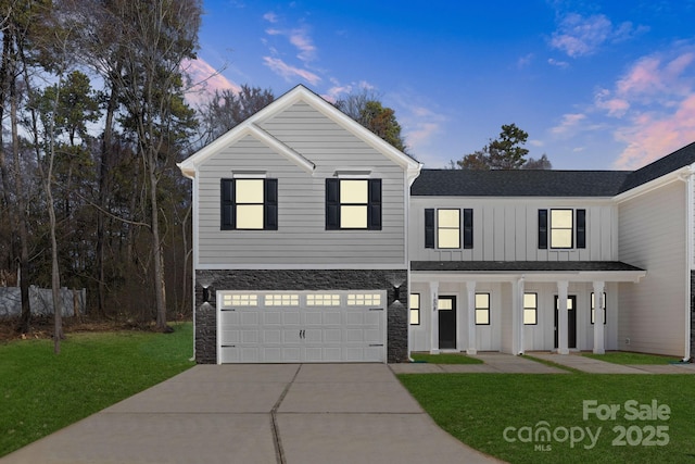1604 Breezewood Dr, Charlotte, NC 28262 - view of front of house with board and batten siding, a yard, an attached garage, concrete driveway, and stone siding