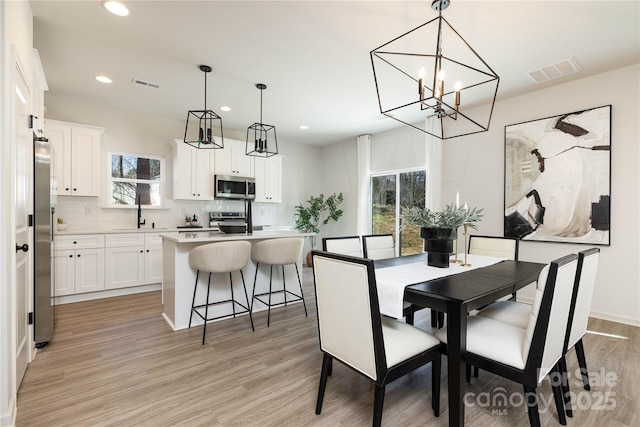 1604 Breezewood Dr, Charlotte, NC 28262 - dining space with an inviting chandelier, recessed lighting, light wood-style flooring, and visible vents