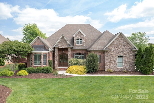 view of front of home with a standing seam roof, stone siding, and a front lawn