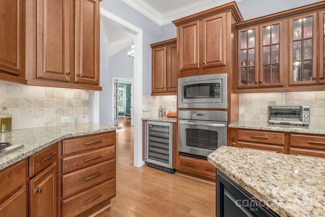 kitchen with appliances with stainless steel finishes, light stone counters, beverage cooler, tasteful backsplash, and ornamental molding