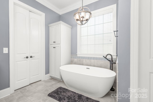 full bathroom featuring crown molding, baseboards, a notable chandelier, and a soaking tub