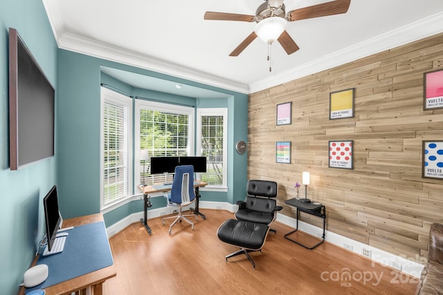 office with wooden walls, baseboards, crown molding, and wood finished floors