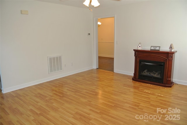 177 Line Dr, Forest City, NC 28043 - unfurnished living room featuring a ceiling fan, baseboards, visible vents, and light wood finished floors