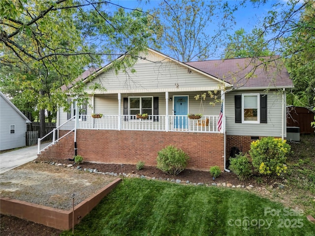 view of front of property featuring a porch, a front lawn, stairs, and cooling unit