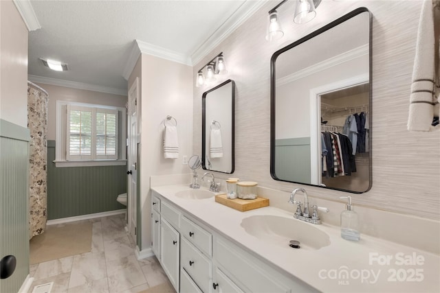 full bathroom with a sink, crown molding, double vanity, and marble finish floor