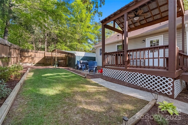 view of yard featuring a fenced backyard, a ceiling fan, and a deck