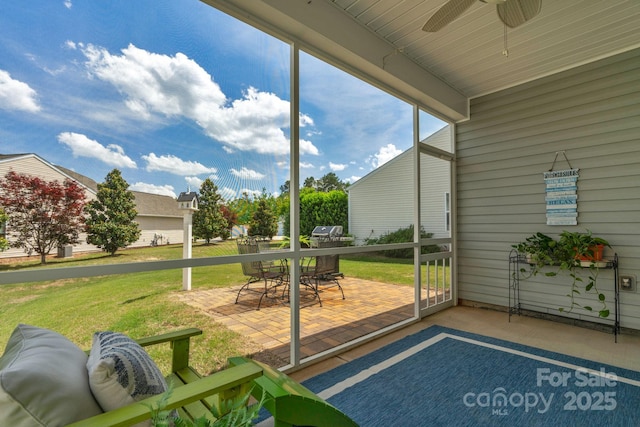 sunroom with outdoor dining area and ceiling fan
