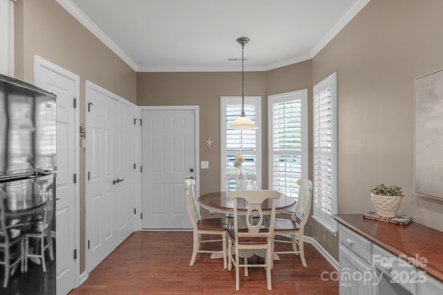 dining area with visible vents, ornamental molding, baseboards, and dark wood-style floors