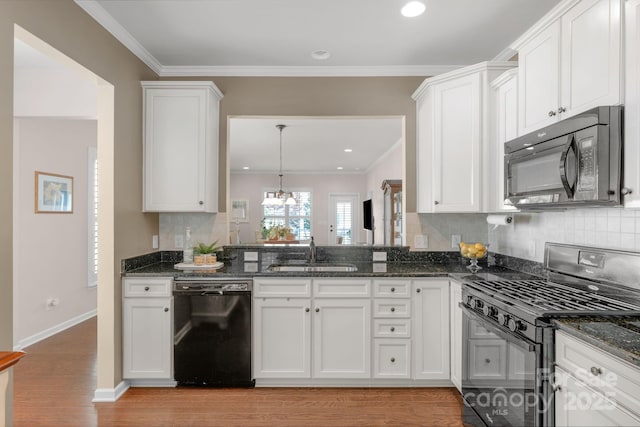 kitchen with a sink, dark stone counters, black appliances, and tasteful backsplash
