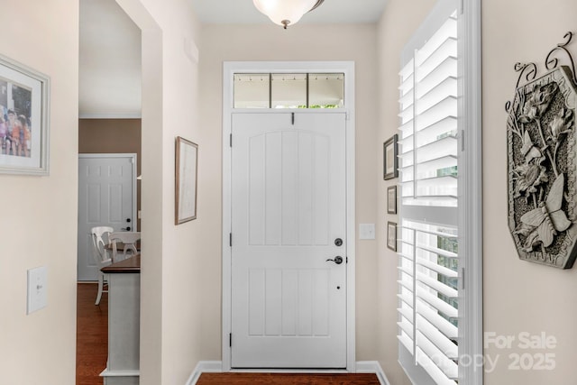 foyer featuring baseboards and wood finished floors