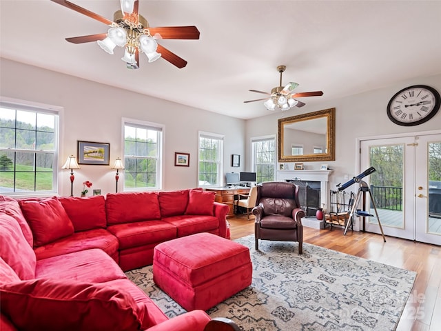 6780 Max Patch Rd, Clyde, NC 28721 - living area with french doors, a fireplace with raised hearth, ceiling fan, and wood finished floors