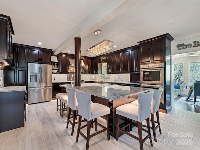 6780 Max Patch Rd, Clyde, NC 28721 - kitchen with stainless steel appliances, light stone counters, light wood-style floors, a kitchen breakfast bar, and recessed lighting