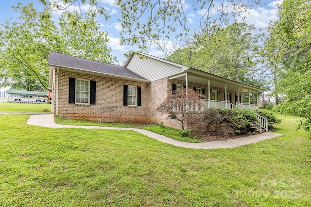 view of front of property with brick siding, a front yard, and a porch