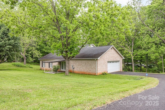 view of side of home with driveway, brick siding, a lawn, an attached garage, and roof with shingles