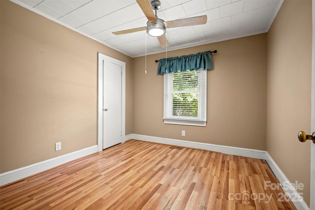 spare room featuring baseboards, a ceiling fan, light wood-style flooring, and visible vents