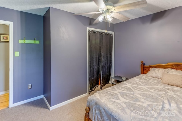 bedroom featuring a closet, a ceiling fan, baseboards, a textured ceiling, and carpet flooring