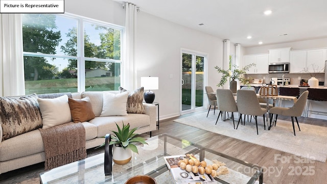 living room featuring recessed lighting, baseboards, and wood finished floors