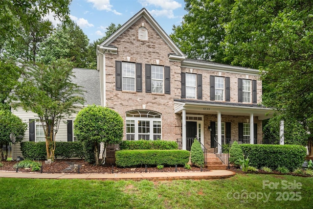 6729 Garden Hill Dr, Huntersville, NC 28078 - view of front of property with brick siding, a front yard, and covered porch
