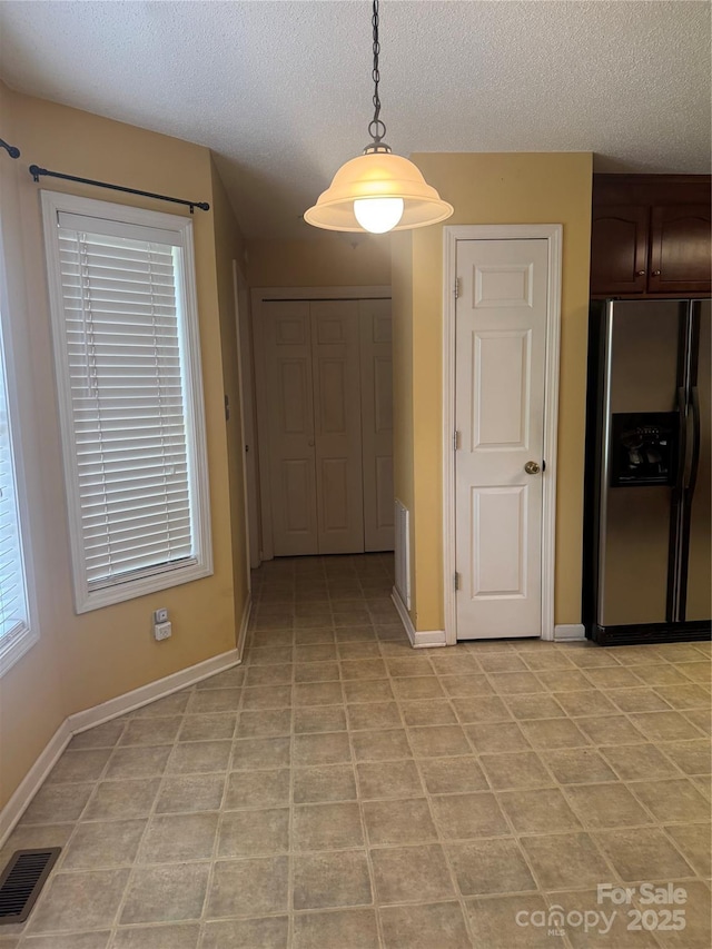 165 Graceland Pl, Salisbury, NC 28146 - unfurnished dining area with a textured ceiling, baseboards, and light tile patterned flooring