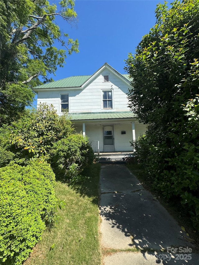 view of front facade with covered porch and metal roof