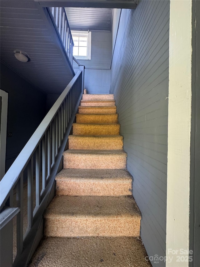 stairs featuring wood walls