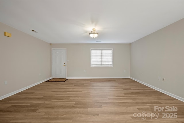 unfurnished room with baseboards, visible vents, and light wood-style flooring