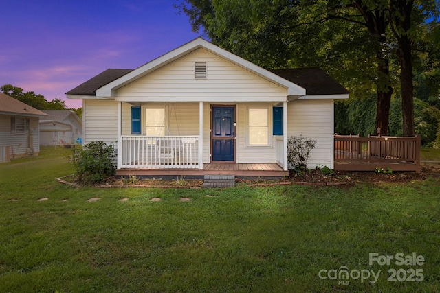 view of front of property with a porch and a lawn