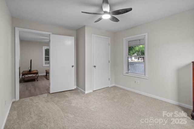 unfurnished bedroom with carpet flooring, baseboards, and a ceiling fan