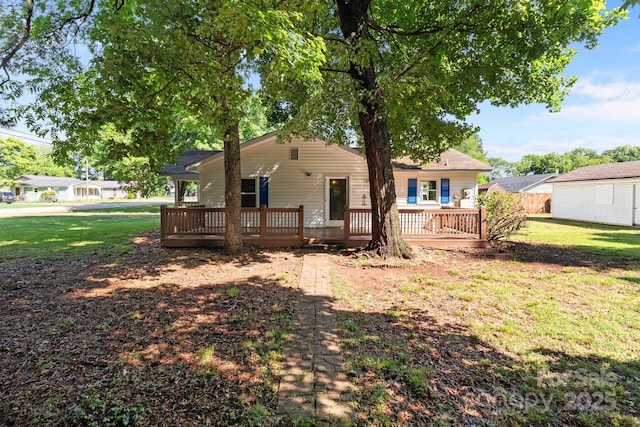 back of property with a deck and a yard