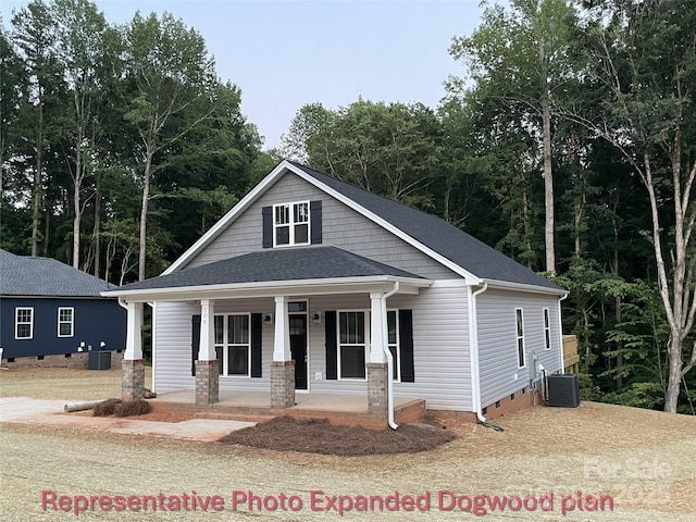 bungalow-style home featuring roof with shingles, central air condition unit, a porch, and crawl space