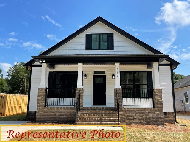 view of front of property featuring fence and a porch