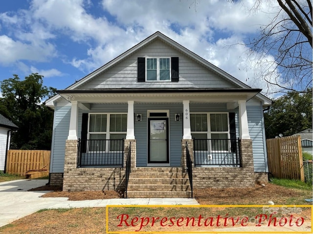 view of front facade featuring fence and covered porch