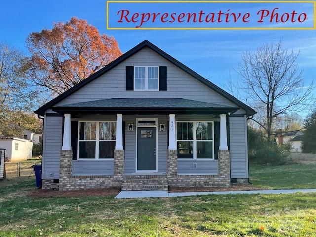 view of front of house featuring fence, covered porch, a front yard, a shingled roof, and crawl space