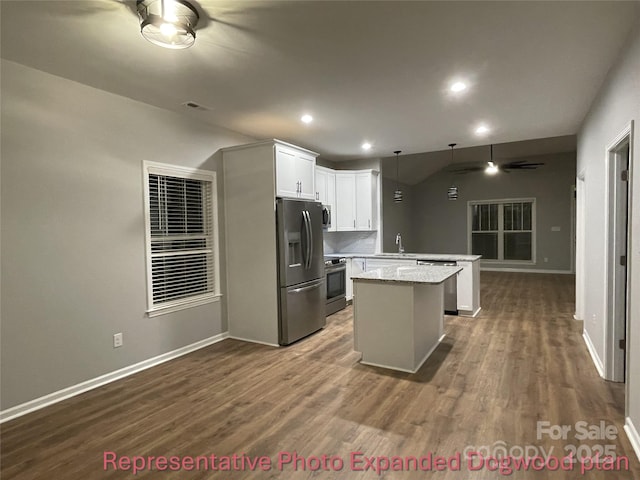 kitchen with visible vents, a center island, a sink, stainless steel appliances, and dark wood-type flooring