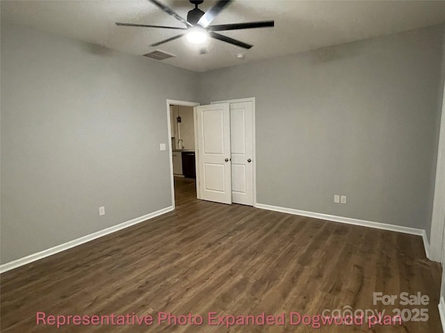 unfurnished bedroom with visible vents, a ceiling fan, baseboards, and dark wood finished floors