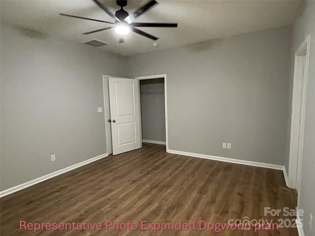 unfurnished bedroom with baseboards, dark wood finished floors, visible vents, and a closet
