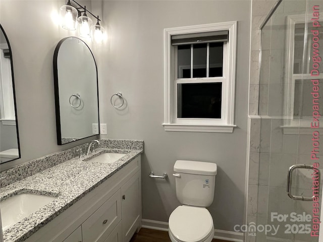 bathroom with baseboards, a sink, a stall shower, and toilet