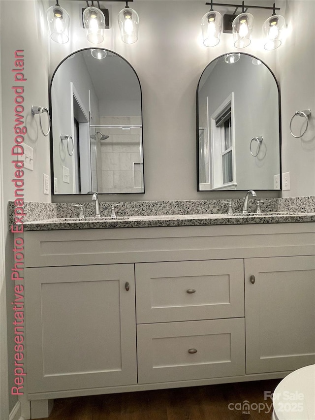 full bathroom featuring double vanity, a sink, and toilet