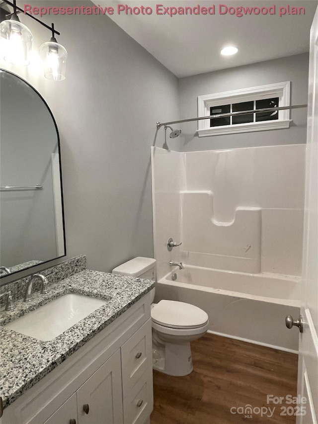 full bath with wood finished floors, vanity, toilet, recessed lighting, and tub / shower combination
