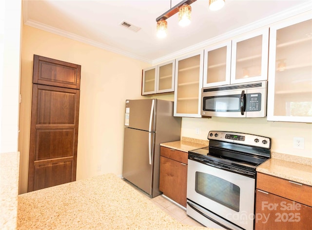 525 N Graham St Unit 3F, Charlotte, NC 28202 - kitchen featuring visible vents, ornamental molding, glass insert cabinets, light stone counters, and appliances with stainless steel finishes