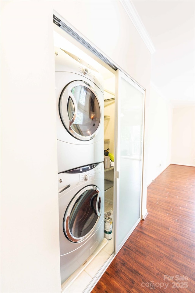 525 N Graham St Unit 3F, Charlotte, NC 28202 - clothes washing area featuring crown molding, stacked washer / drying machine, wood finished floors, and laundry area