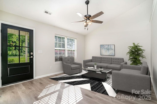 living room featuring visible vents, plenty of natural light, wood finished floors, and lofted ceiling