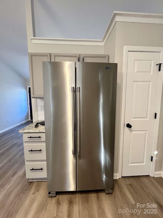details with high end refrigerator, baseboards, gray cabinets, and light wood-style floors