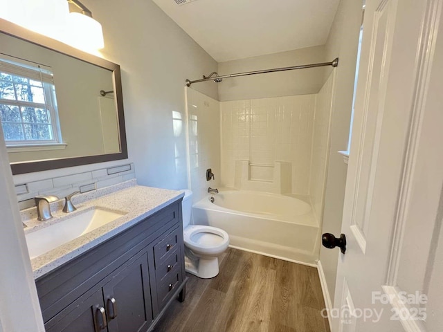 full bathroom featuring toilet, tub / shower combination, wood finished floors, and vanity
