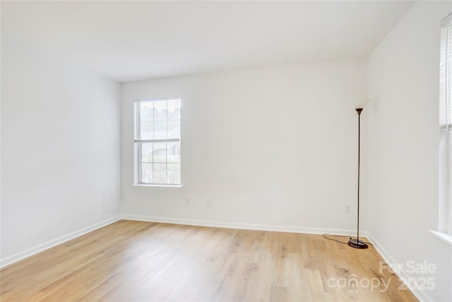 spare room featuring light wood-style floors and baseboards
