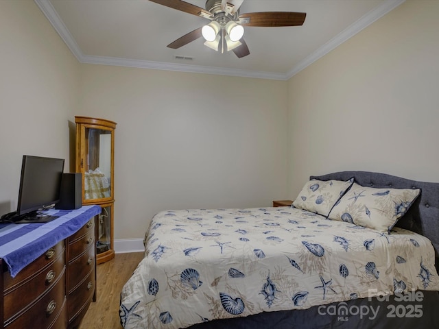bedroom featuring crown molding, ceiling fan, baseboards, wood finished floors, and visible vents