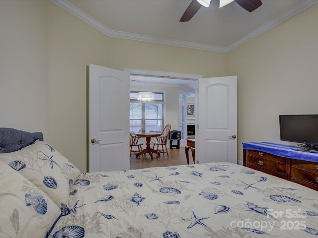 bedroom featuring a ceiling fan, ornamental molding, and wood finished floors
