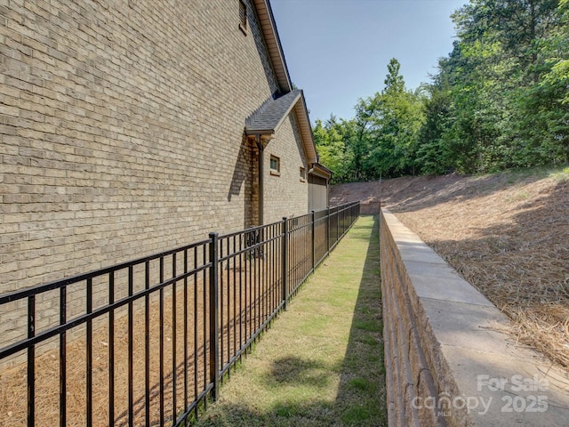 view of side of home featuring brick siding and fence
