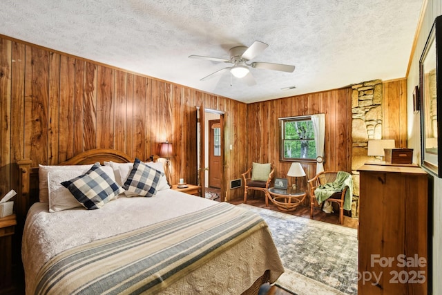 675 Terrys Gap Rd, Hendersonville, NC 28792 - bedroom with wooden walls, a textured ceiling, and a ceiling fan